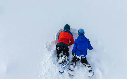 Children snowshoeing in deep snow during Lapland tour, Rovaniemi.