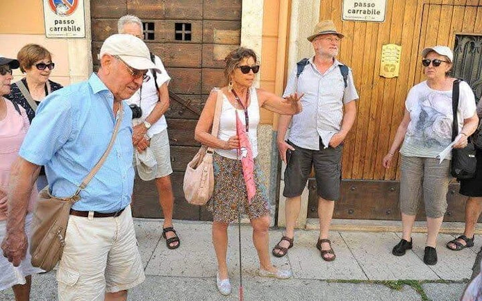 Tour group with guide in Verona, Italy, during city tour before Arena di Verona opera visit.