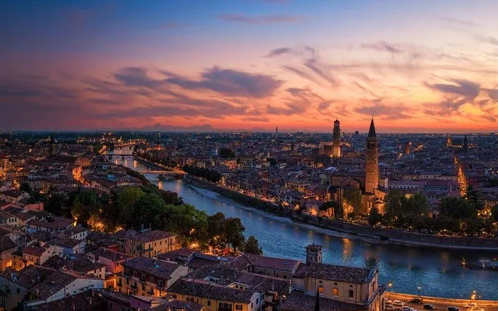 Verona cityscape at sunset with Adige River and historic buildings, Italy.