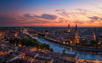 Verona cityscape at sunset with Adige River and historic buildings, Italy.