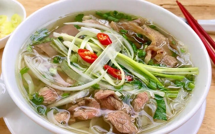 Pho noodle soup with beef, herbs, and chili, part of a cooking class with a local chef.