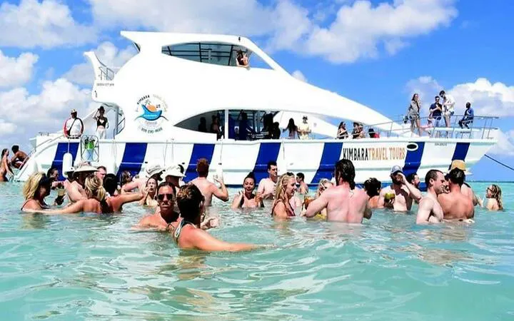 Tourists enjoying a snorkeling boat cruise with open bar in Punta Cana's natural pool.