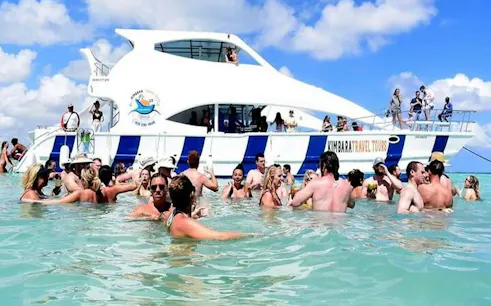 Tourists enjoying a snorkeling boat cruise with open bar in Punta Cana's natural pool.