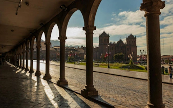 Arched walkway overlooking Cusco Historic Center with cathedral in view.