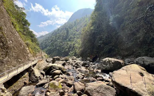Sapa mountain path with rocky stream leading to Dragon Waterfall, Vietnam.