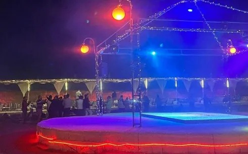 Outdoor dinner show with stage lighting in Sharm El Sheikh desert setting.