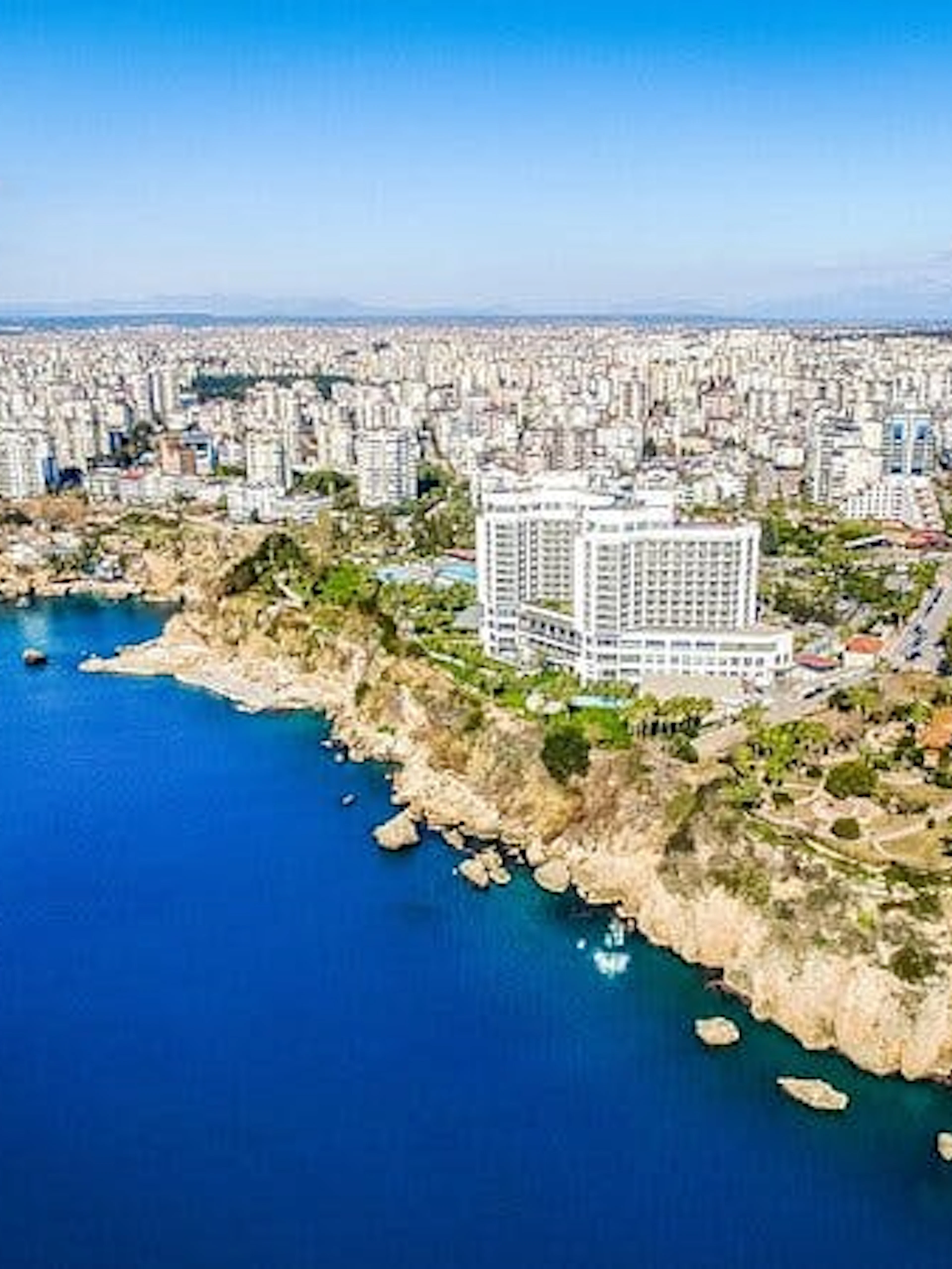 Aerial view of Antalya coastline with cityscape and cliffs, Turkey.