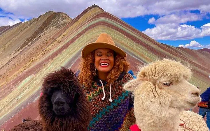 Person smiling with alpacas at Rainbow Mountain, Cusco, during early access tour.