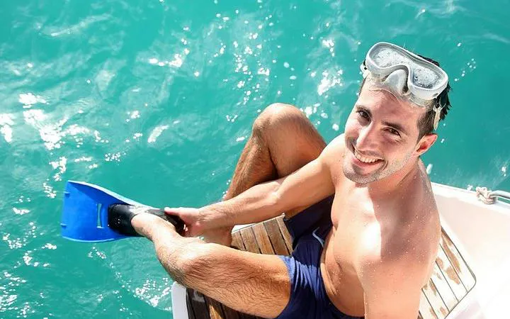 Snorkeler preparing to enter turquoise waters on a catamaran cruise in Punta Cana.