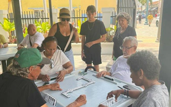 People playing dominoes at a table in Little Havana, Miami, during a guided walking tour.