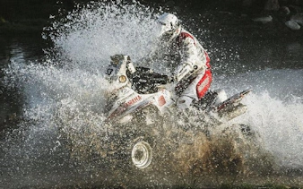 Quad bike splashing through water on Krakow off-road tour.