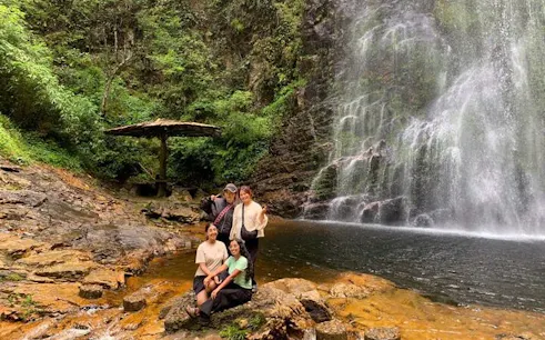 Visitors at a waterfall in Sapa, Vietnam, surrounded by lush greenery.