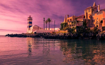 Cascais coastline with Santa Marta Lighthouse and historic buildings during self-guided walking tour.