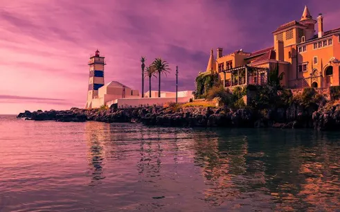Cascais coastline with Santa Marta Lighthouse and historic buildings during self-guided walking tour.