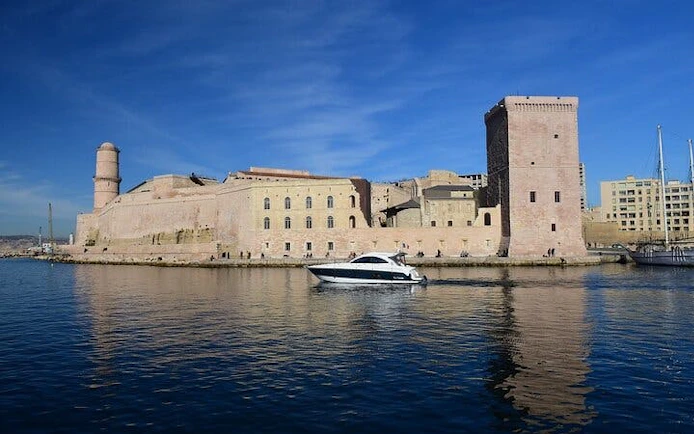 Fort Saint-Jean by the sea in Marseille with a boat in the foreground.