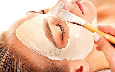 Applying facial mask during Moroccan Hammam ritual in Marrakesh bathhouse.