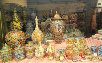 Florence artisan ceramics display with colorful vases and pottery in a workshop setting.