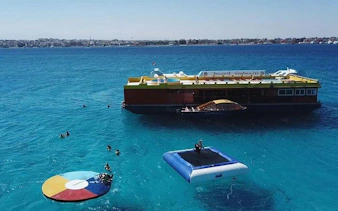 Semi-submarine and snorkelers in clear Hurghada waters with floating platforms.