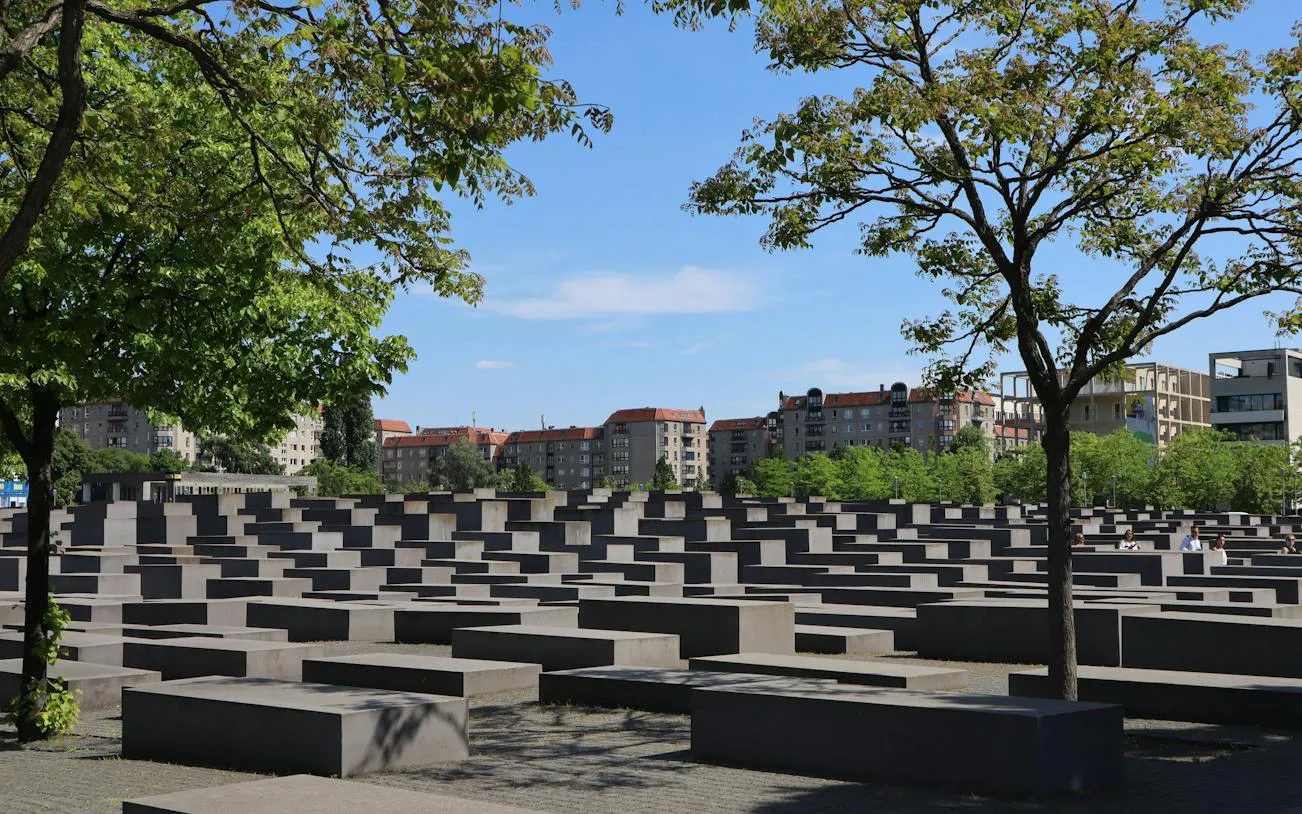 Holocaust Memorial in Berlin with concrete slabs and surrounding trees.