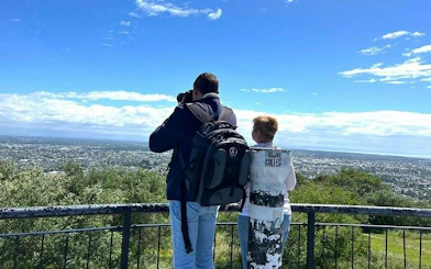 Tourists enjoying panoramic view of Christchurch from lookout point on half-day city tour.