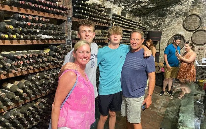 Family in a Tuscan wine cellar during a day trip from Rome with wine tastings.