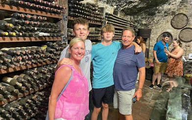 Family in a Tuscan wine cellar during a day trip from Rome with wine tastings.