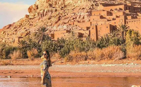 Ait Benhaddou kasbah with visitor by the river, Marrakesh tour.