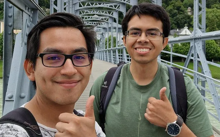 Two people giving thumbs up on a bridge in Salzburg during a self-guided city exploration game.