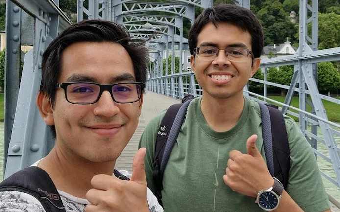 Two people giving thumbs up on a bridge in Salzburg during a self-guided city exploration game.