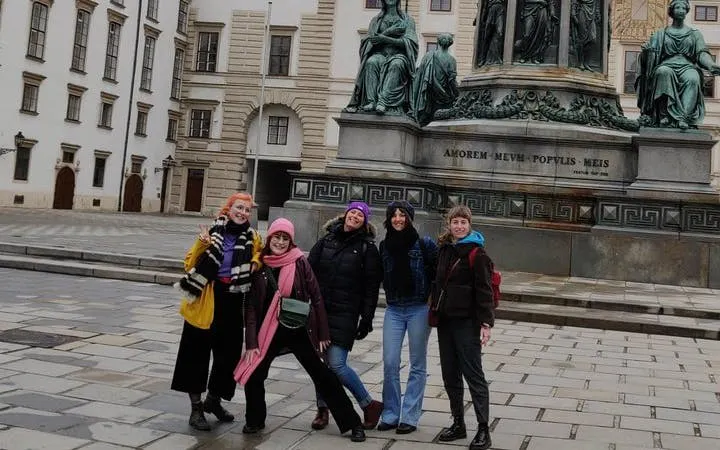 Group of people in front of a statue at Hofburg Palace, Vienna, during a self-guided city exploration game.