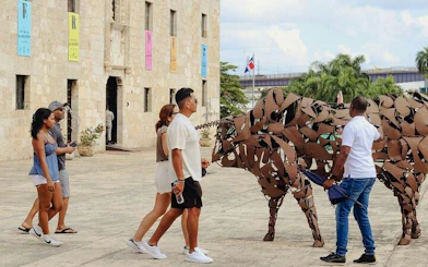 Visitors exploring metal sculptures in Santo Domingo Colonial Zone, Dominican Republic.