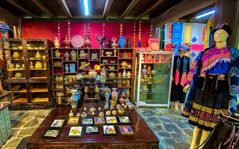 Sapa museum interior with traditional artifacts and ethnic clothing display.
