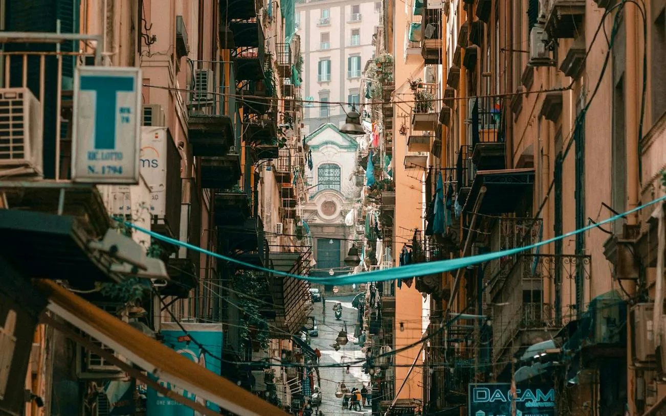 Narrow street in Naples Historic Center with view of Spaccanapoli and local architecture.