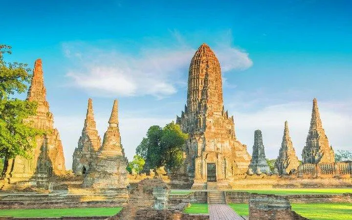 Ayutthaya temple ruins with ancient spires under blue sky, part of Bangkok guided tour.