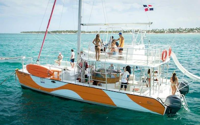 Catamaran with guests enjoying snorkeling cruise, open bar, and slide in Punta Cana.