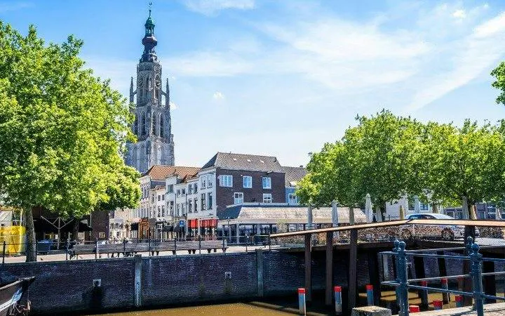 Breda cityscape with Grote Kerk tower and canal, featured in self-guided audio tour.