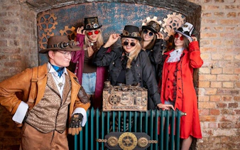 Group in steampunk attire at Time Machine Budapest exhibition.