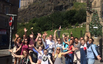 Group enjoying Harry Potter walking tour in Edinburgh near historic castle.