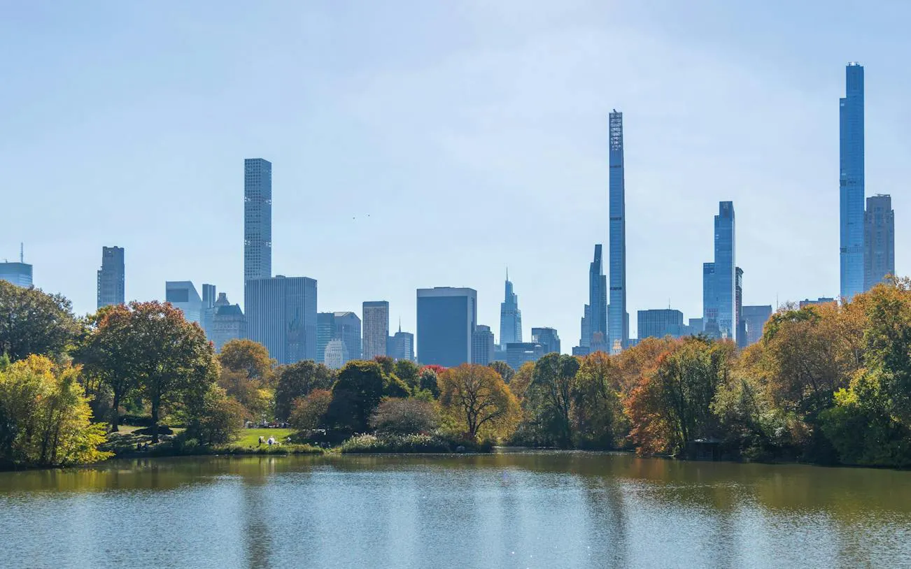 Central Park lake with New York City skyline in the background during a self-guided audio walking tour.
