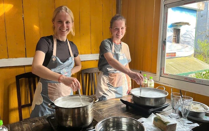 Tofu-making class in Sa Pa with participants stirring soy milk in pots.