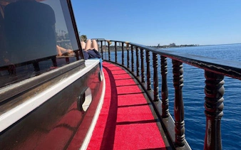 Boat deck with red carpet on Antalya Lower Duden Waterfall tour, overlooking the sea.