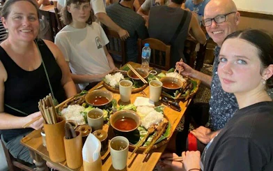 Group enjoying traditional Vietnamese street food in Hanoi during motorbike tour.