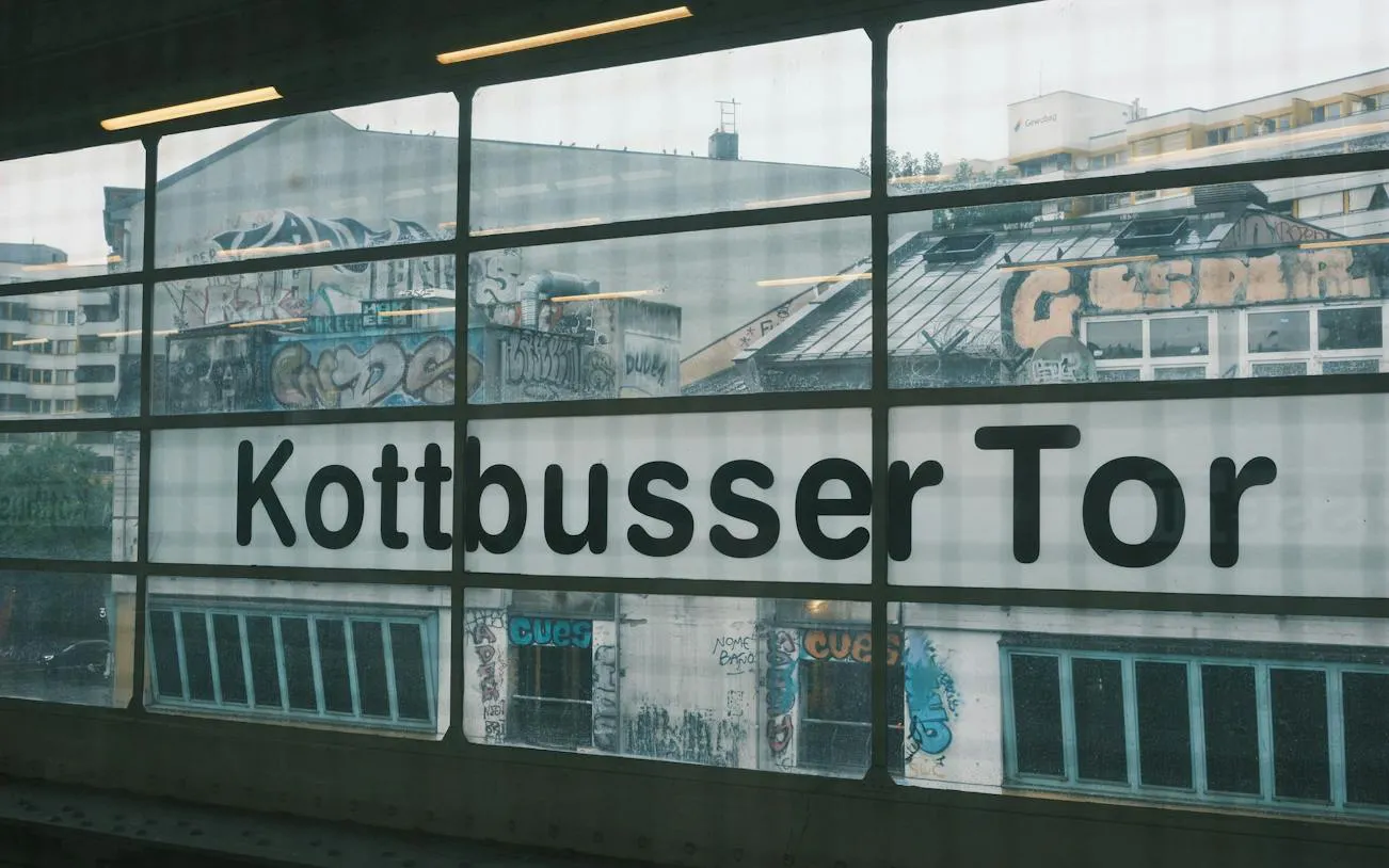 Kottbusser Tor station window with graffiti-covered buildings in Kreuzberg, Berlin.