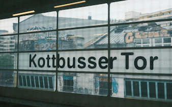 Kottbusser Tor station window with graffiti-covered buildings in Kreuzberg, Berlin.