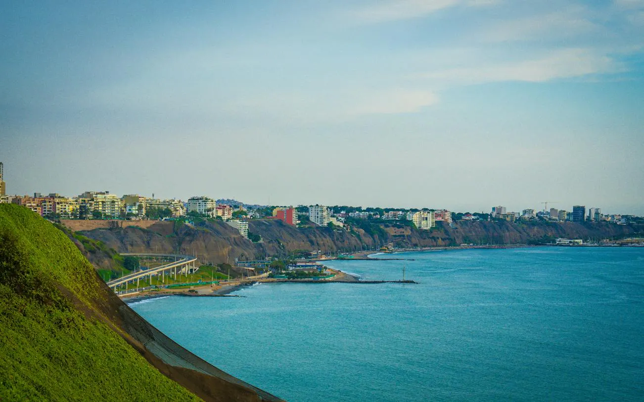 Lima Barranco coastline with cliffs and cityscape, part of self-guided audio walking tour.