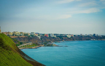 Lima Barranco coastline with cliffs and cityscape, part of self-guided audio walking tour.