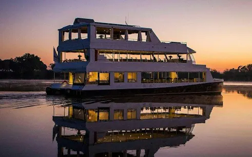 Sunset river cruise boat on the Zambezi River, part of the Victoria Falls Full Day Experience.