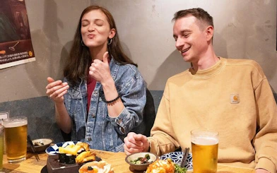 Shinjuku bar patrons enjoying sushi and drinks during Tokyo night tour.