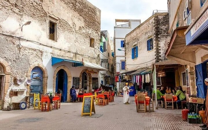 Essaouira street scene with outdoor dining and local shops during city tour.