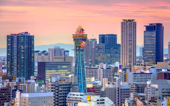 Osaka skyline with Tsutenkaku Tower at sunset near Shinsaibashi and Dotonbori.
